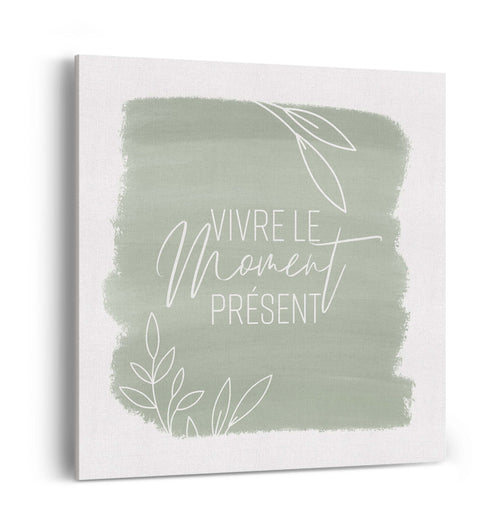 Toile carrée murale blanche avec encadré vert sauge et texte vivre le moment présent.